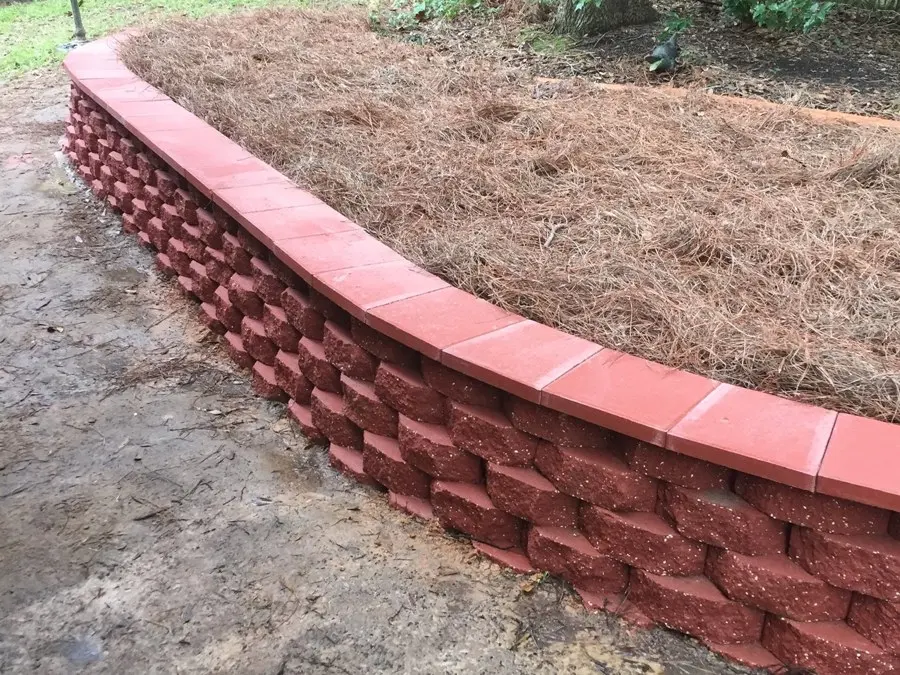 New brick retaining wall bed filled with pine straw