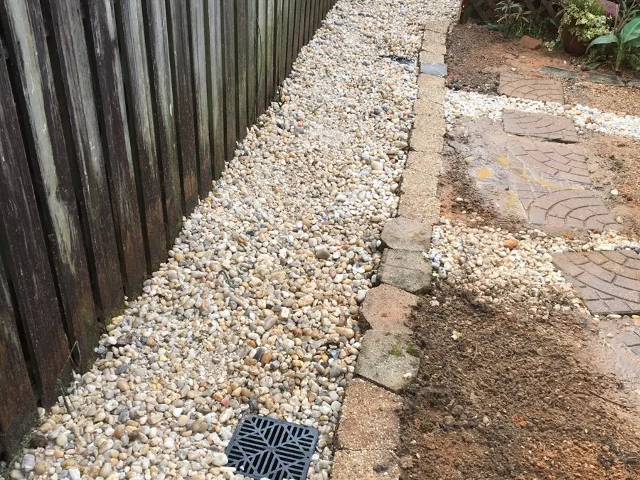 Gravel drainage strip along a wood fence